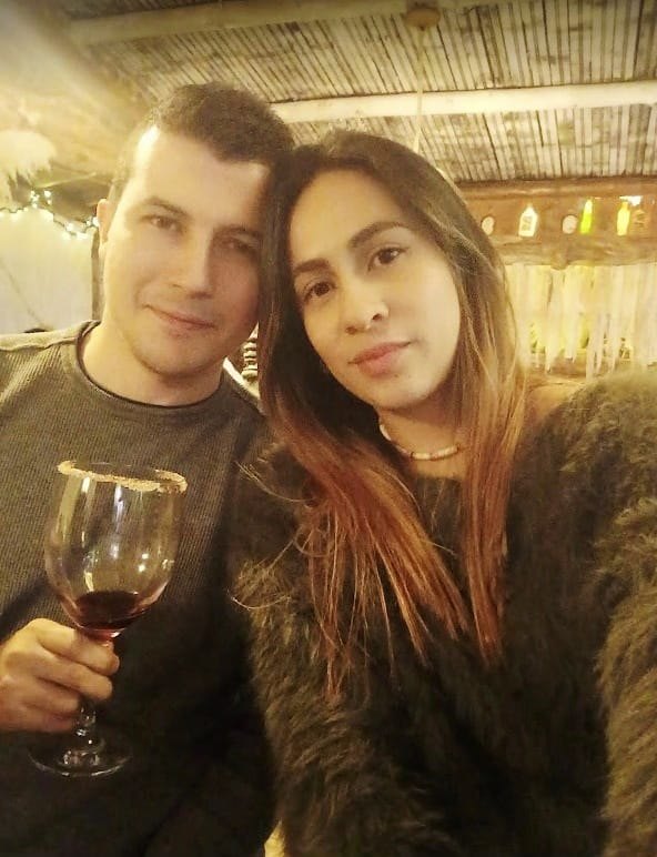 Daniela y Anderson brindando con una copa de vino